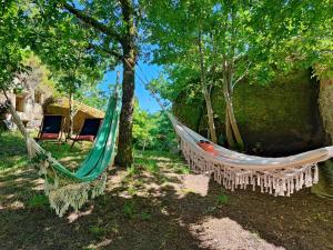 two hammocks hanging from trees in a yard at Casa do Penedo in Castro Laboreiro