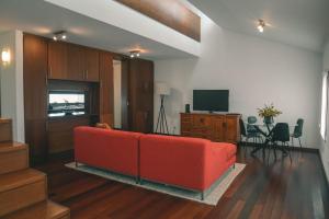 马达莱纳Rauls Place的客厅里有一张红色的沙发和一台电视