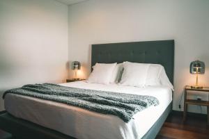a bedroom with a large bed with a green headboard at Rauls Place in Madalena