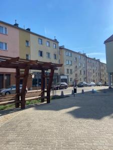 eine Holzbank vor einem Gebäude in der Unterkunft Mieszkanko w Perle Mazur-Ostroda in Ostróda + 4 Fotos