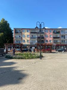 eine Straßenlaterne in einem Park mit Gebäuden im Hintergrund in der Unterkunft Mieszkanko w Perle Mazur-Ostroda in Ostróda
