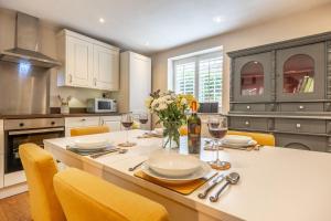 a kitchen with a table with glasses of wine at Sherbet Cottage in South Creake