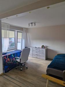a bedroom with a bed and a desk and a chair at Penthouse apartment Baltupiai in Vilnius