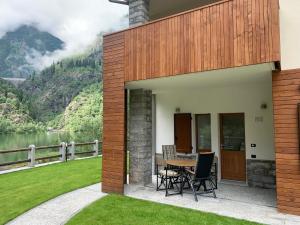 a patio with a table and chairs and a view of a mountain at Casa Sajont in Antronapiana