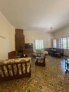 Una sala de estar con un sofá y sillas y una mesa. en Villa San Michele by STHEY, en Impalata