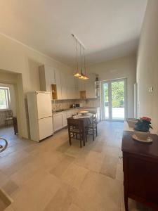 Una cocina con una mesa y un refrigerador blanco. en Villa San Michele by STHEY, en Impalata