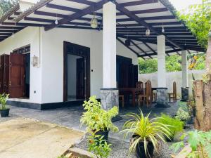 a porch of a house with a patio at Korea inn Hotel in Weligama