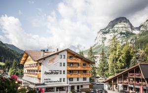 a hotel in the mountains with mountains in the background at Hotel Ladinia in La Villa