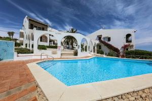 a villa with a swimming pool in front of a house at Apartament Cargol in Es Mercadal