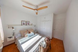a bedroom with a bed with a ceiling fan at Apartament Cargol in Es Mercadal