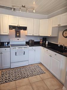 una cocina con armarios blancos y un horno de fogón blanco en Paradise Cove on Lemon Bay, en Englewood 31 fotos más