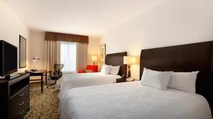 a hotel room with two beds and a television at Hilton Garden Inn Edmonton International Airport in Leduc +23 photos