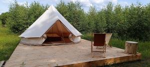 a tent on a wooden deck in a field at Siedlisko Stasin in Trojanów
