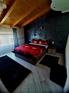a bedroom with a red bed with red pillows at Vila Bijou in Borşa +50 photos