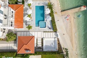 een uitzicht over een huis met een zwembad en het strand bij Luxury beachfront Villa Providenca in Podstrana