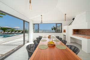 een eetkamer met een lange houten tafel en stoelen bij Luxury beachfront Villa Providenca in Podstrana