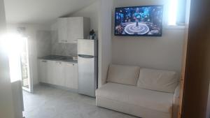 a kitchen with a white couch and a refrigerator at Gialì House in Agropoli