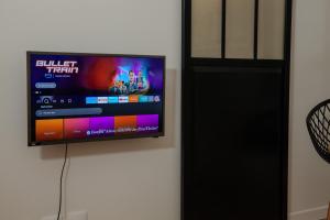 ein Flachbildfernseher, der an einer Wand hängt in der Unterkunft Cosy one bedroom close to Paris & Stade de France in Saint-Denis + 6 Fotos