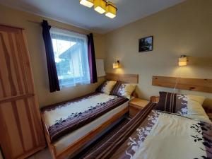a bedroom with two beds and a window at Domki Letniskowe Cyprys in Chańcza +24 photos