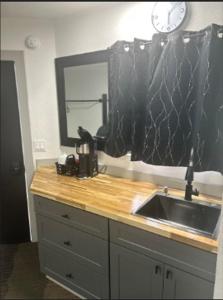 a kitchen counter with a sink and a clock on the wall at The Silverwood Lodge in Athol +21 photos