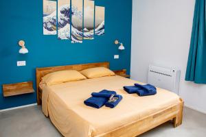 a bedroom with a bed with two blue towels on it at Villa del Lupo in Santa Maria la Palma