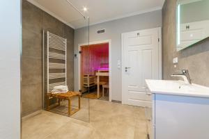 a bathroom with a sink and a glass shower at Hus in Luv in Greetsiel