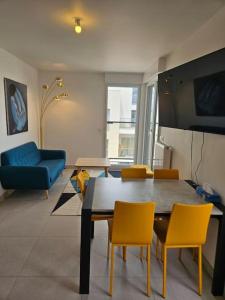 a living room with a table and yellow chairs at Appartement neuf en duplex in Saint-Maur-des-Fossés