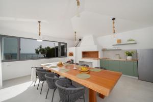 een keuken en eetkamer met een houten tafel en stoelen bij Luxury beachfront Villa Providenca in Podstrana +47 foto's