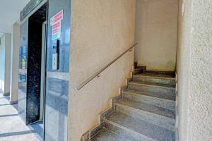a stairway leading to a building with a glass door at Hotel O PMR Hotel in Bengaluru +23 photos
