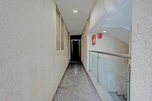 a long hallway with a dark tunnel in a building at Hotel O PMR Hotel in Bengaluru