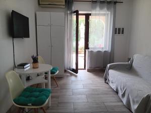 a bedroom with a bed and a table and a television at Apartman Tatjana in Senj