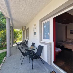 a patio with chairs and a table and a bed at Apartmani Vlahović in Sutomore