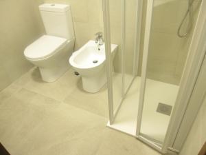 a white bathroom with a toilet and a shower at Argea in Grado +24 photos