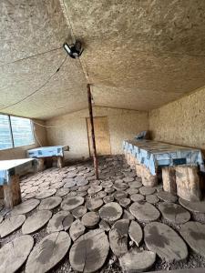 a room with a stone floor with a table and benches at "Ethno Yurt Camp Argymak" Altyn Arashan in Mineralʼnyy Istochnik Altyn-Arasan