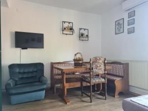 a living room with a table and a chair and a tv at Green door 2 in Vrnjačka Banja