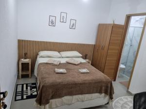 a bedroom with a bed with two towels on it at Studio fantástico in São Paulo