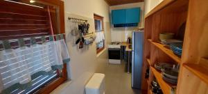 a small kitchen with a refrigerator and a stove at Premantura Studio apartman in Premantura +23 photos