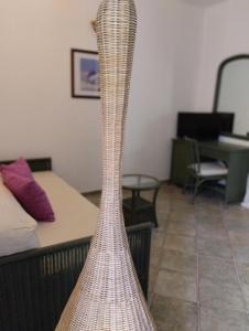 a rattan floor lamp in a room with a bed at Valle di Mare Country Resort in Fontane Bianche