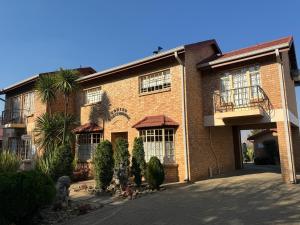 a large brick building with trees in front of it at Rooiberg View Clarens in Clarens