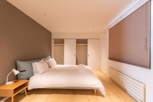 a bedroom with a large white bed and a window at Snow Monkey Loft in Kutchan