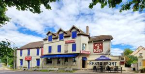 a restaurant building with blue trim on a street at Aux Trois Rois in Pont-sur-Yonne
