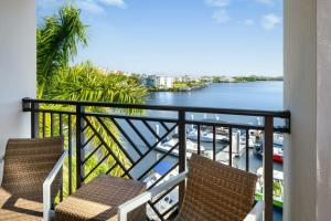 a balcony with two chairs and a view of the water at Hyatt House Naples 5th Avenue in Naples