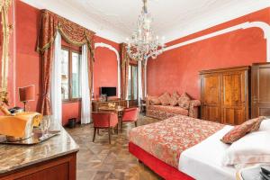 a bedroom with red walls and a bed and a desk at Hotel San Mois&egrave; in Venice