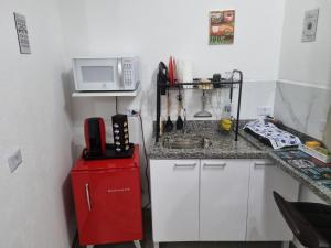 a small kitchen with a sink and a microwave at Studio fantástico in São Paulo