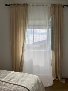 een slaapkamer met een bed en een groot raam bij Casa do Montinho in Caminha +6 foto's