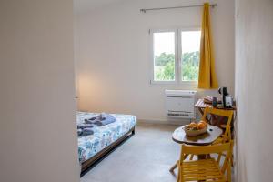 a bedroom with a bed and a table and a window at Villa del Lupo in Santa Maria la Palma