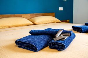 a bed with two blue towels on top of it at Villa del Lupo in Santa Maria la Palma