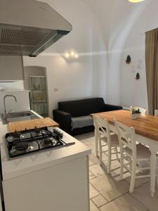 una cocina con estufa horno superior junto a la sala de estar en Augustus B&B, en Terlizzi