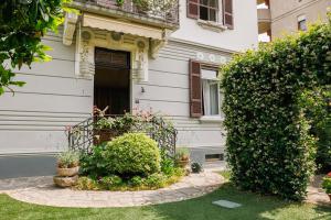 a white house with a gate and a bush at Doriana's House with Garden & Parking in Maslianico