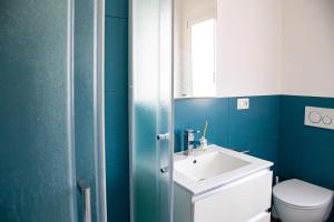a blue bathroom with a sink and a toilet at Villa del Lupo in Santa Maria la Palma